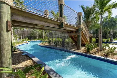 a bridge over a pool with a water slide at Storey Lake Resort Just 5 Minutes to Mickey Mouse in Kissimmee