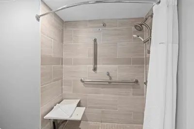 a bathroom with a shower with a toilet and a sink at Baymont by Wyndham Orlando East in Orlando