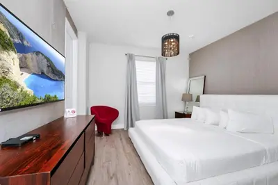 a white bedroom with a large bed and a tv at Striking Home With Games, Outdoor Kitchen Near Disney With Waterpark & Resort Access At Encore Resort - 7742Ff in Kissimmee