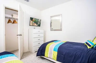a bedroom with a bed and a dresser and a mirror at Four Bedroom Close to Disney 5149A in Kissimmee