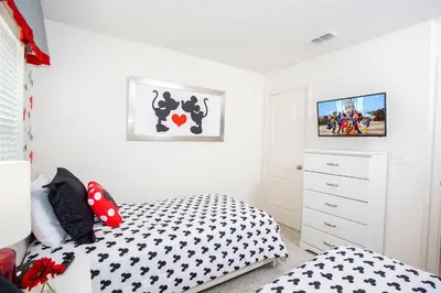a bedroom with a black and white bed and a dresser at Four Bedroom Close to Disney 5149A in Kissimmee