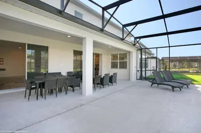 an outdoor patio with black chairs and a table at Sonoma Resort 7 Bedroom Home with Pool 1849 in Kissimmee
