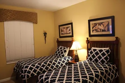 a bedroom with two beds and a lamp and a window at Viz Cay Apartment 202 in Orlando