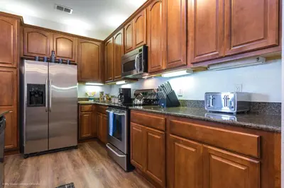 a kitchen with wooden cabinets and stainless steel appliances at Casa Magna Condo #152742 in Orlando