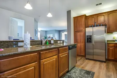 a kitchen with wooden cabinets and a stainless steel refrigerator at Casa Magna Condo #152742 in Orlando
