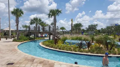 a man standing in a pool at a resort at 4 Bedroom Private Lakefront Town Home at Storey Lake near Disney World Parks in Kissimmee