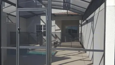 a view from inside a house through a glass door at 4 Bedroom Private Lakefront Town Home at Storey Lake near Disney World Parks in Kissimmee