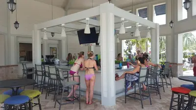 a group of women in bathing suits standing at a bar at 4 Bedroom Private Lakefront Town Home at Storey Lake near Disney World Parks in Kissimmee