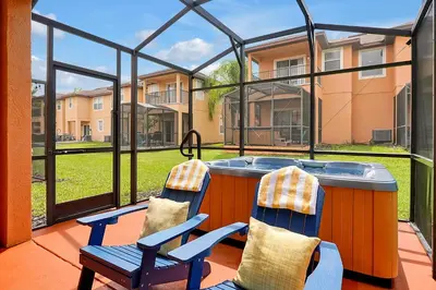a patio with two chairs and a hot tub at Regal Oaks Resort Vacation Townhomes by IDILIQ in Orlando