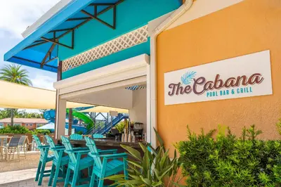a restaurant with blue chairs outside of a building at Regal Oaks Resort Vacation Townhomes by IDILIQ in Orlando