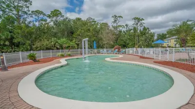 a pool with a water fountain in a park at Barefoot Suite in Orlando