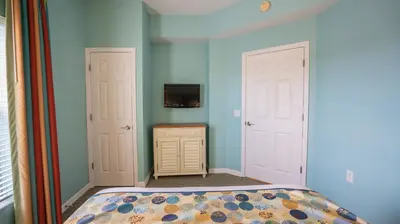 a bedroom with a bed and two white doors at Barefoot Suite in Orlando