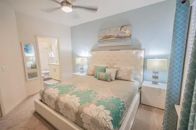a bedroom with a large bed and a mirror at Dream Vacation Home! in Kissimmee