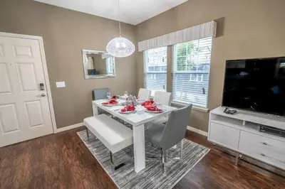 a dining room with a white table and a tv at Dream Vacation Home! in Kissimmee