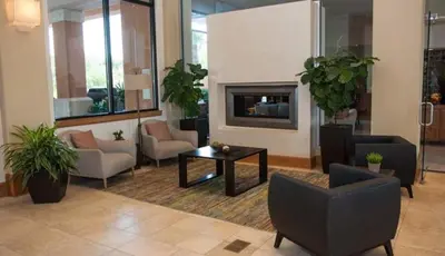 a lobby with chairs and a table and a fireplace at Scarlet in Orlando