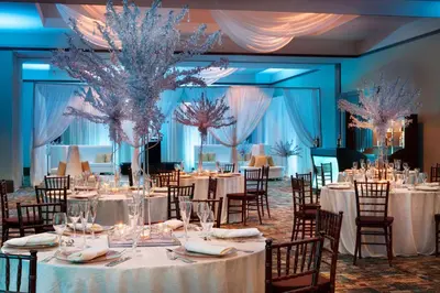 a banquet hall with tables and chairs with white table linens at Embassy Suites by Hilton Orlando Lake Buena Vista South in Kissimmee