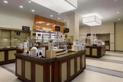 a restaurant with a counter with food on it at Embassy Suites by Hilton Orlando Lake Buena Vista South in Kissimmee