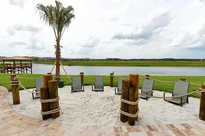 a group of chairs and a palm tree next to a lake at 3083 TS-SVH Storey Lake in Kissimmee
