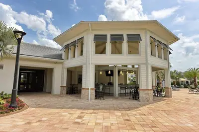 a white house with chairs and tables in front of it at 3083 TS-SVH Storey Lake in Kissimmee