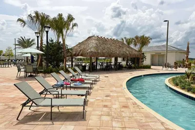a group of chairs and a swimming pool with a resort at 3083 TS-SVH Storey Lake in Kissimmee