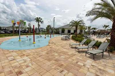 a pool of water with benches and palm trees at 3083 TS-SVH Storey Lake in Kissimmee