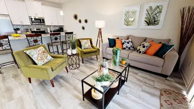 a living room with a couch and chairs and a kitchen at 3083 TS-SVH Storey Lake in Kissimmee