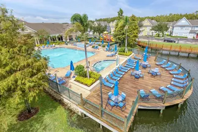 an aerial view of a pool with chairs and a deck at 4 Bedroom Townhouse in a Gated Resort! in Kissimmee