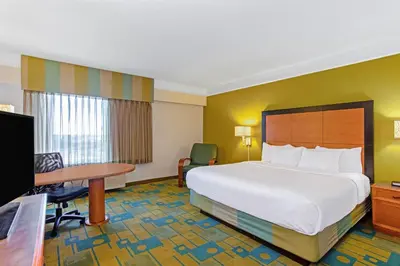 a hotel room with a large bed and a desk at La Quinta by Wyndham Orlando I Drive/Conv Center in Orlando