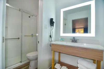 a bathroom with a sink and a shower and a toilet at Hotel Monreale Express & Studios IDrive District in Orlando