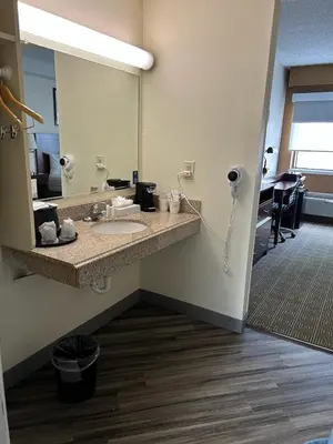 a bathroom with a sink and a mirror at Baymont by Wyndham Orlando South in Orlando