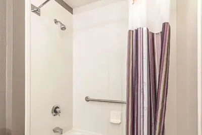 a bathroom with a shower with a shower curtain at La Quinta by Wyndham Orlando UCF in Orlando