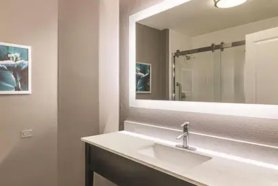 a bathroom with a sink and a large mirror at La Quinta by Wyndham Orlando UCF in Orlando