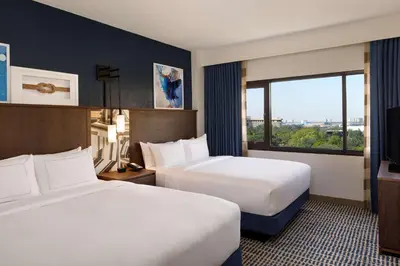 a hotel room with two beds and a window at DoubleTree Suites by Hilton Orlando at Disney Springs in Orlando