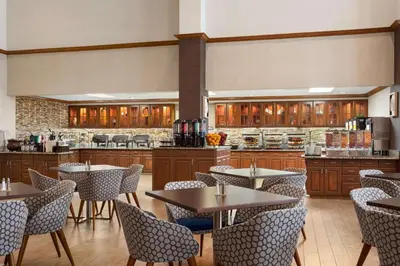 a restaurant with tables and chairs and a kitchen at Homewood Suites by Hilton Orlando-International Drive Convention Center in Orlando