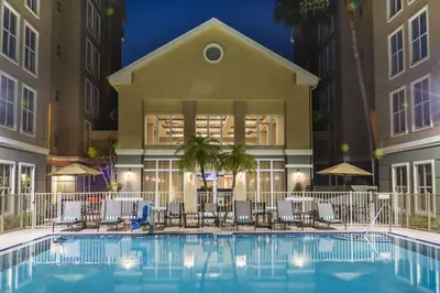 a swimming pool with chairs and a building at Homewood Suites by Hilton Orlando-International Drive Convention Center in Orlando