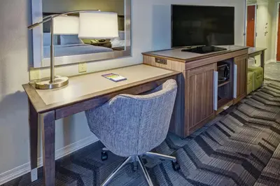 a room with a desk with a lamp and a television at Hampton Inn & Suites Clermont in Clermont