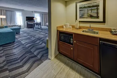 a hotel room with a sink and a living room at Hampton Inn & Suites Clermont in Clermont