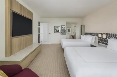 a hotel room with two beds and a flat screen tv at Hilton Orlando in Orlando