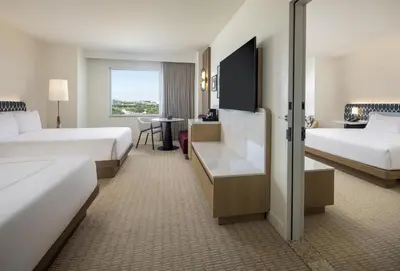 a hotel room with two beds and a desk at Hilton Orlando in Orlando