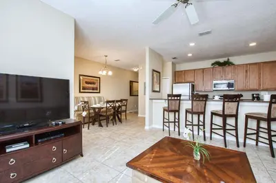 a living room and kitchen with a flat screen tv at Paradise Palms-4 Bed Townhome W-Splashpool-3044Ppr in Kissimmee