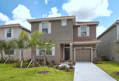 a house with a garage and palm trees at Paradise Palms- 6 Bedroom Pool Home-3150Pp in Kissimmee