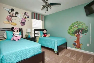 a bedroom with two beds with mickey mouse characters on the wall at House Wpool And Jacuzzi In Paradise Palms-3151Pp in Kissimmee