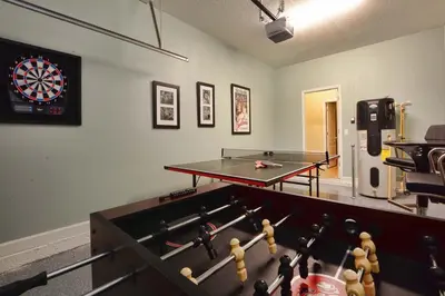 a room with a pool table and a dart board at House Wpool And Jacuzzi In Paradise Palms-3151Pp in Kissimmee