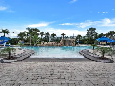 a large swimming pool with trees and blue umbrellas at Close To Clubhouse, Splashpool-3026Pp in Kissimmee