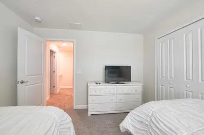 a bedroom with a tv on a dresser with a bed at Lakefront Retreat Wpvt Splashpool-1617St in Kissimmee
