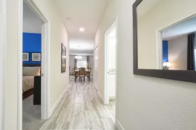 a hallway with a mirror and a dining room at Lakefront Retreat Wpvt Splashpool-1617St in Kissimmee
