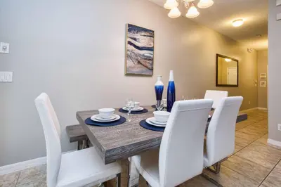 a dining room with a wooden table and white chairs at Bright & Cheery Decor, Townhome Wspashpool-3015Pp in Kissimmee