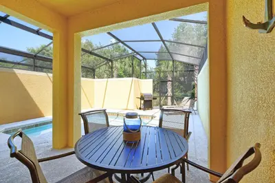 a blue table and chairs on a patio at Paradise Palms-4 Bed Townhouse Wsplashpool3622Ppr in Kissimmee