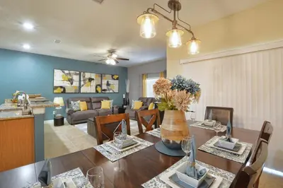 a dining room and living room with a table and a couch at Paradise Palms-4 Bed Townhouse Wsplashpool3622Ppr in Kissimmee