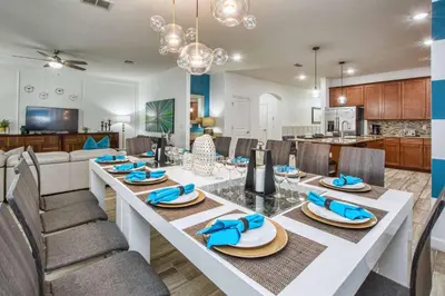 a dining room and kitchen with a large white table and chairs at Across From Clubhouse, Private PoolSpa-1651Str in Kissimmee